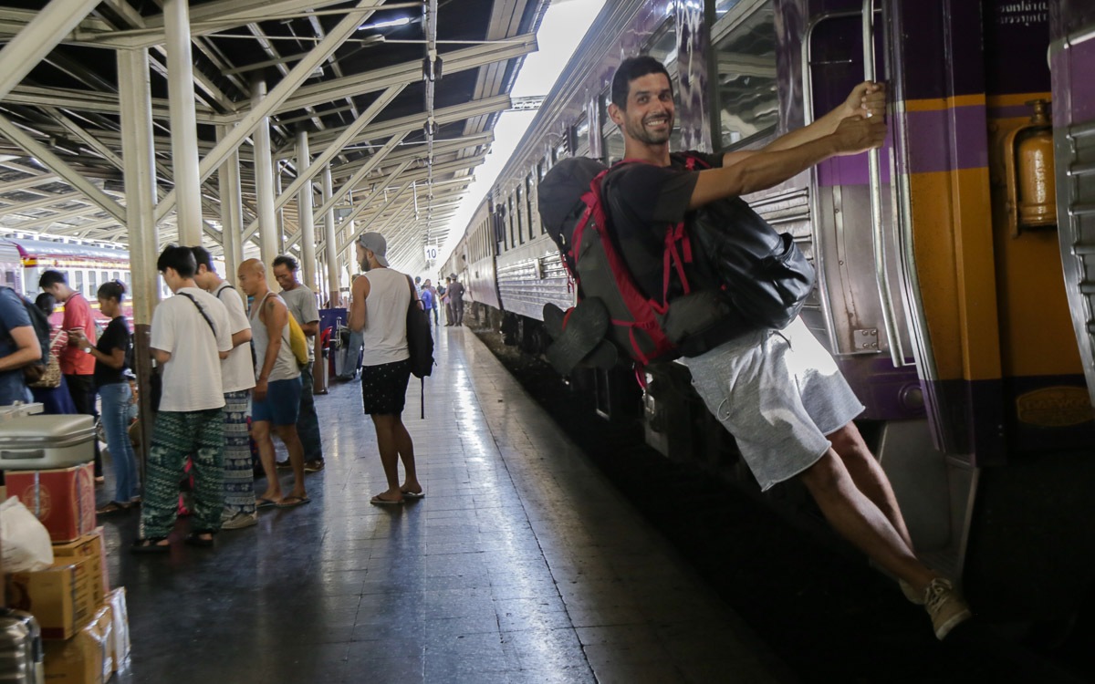 homem com mochila nas costasem vagão trem na estação