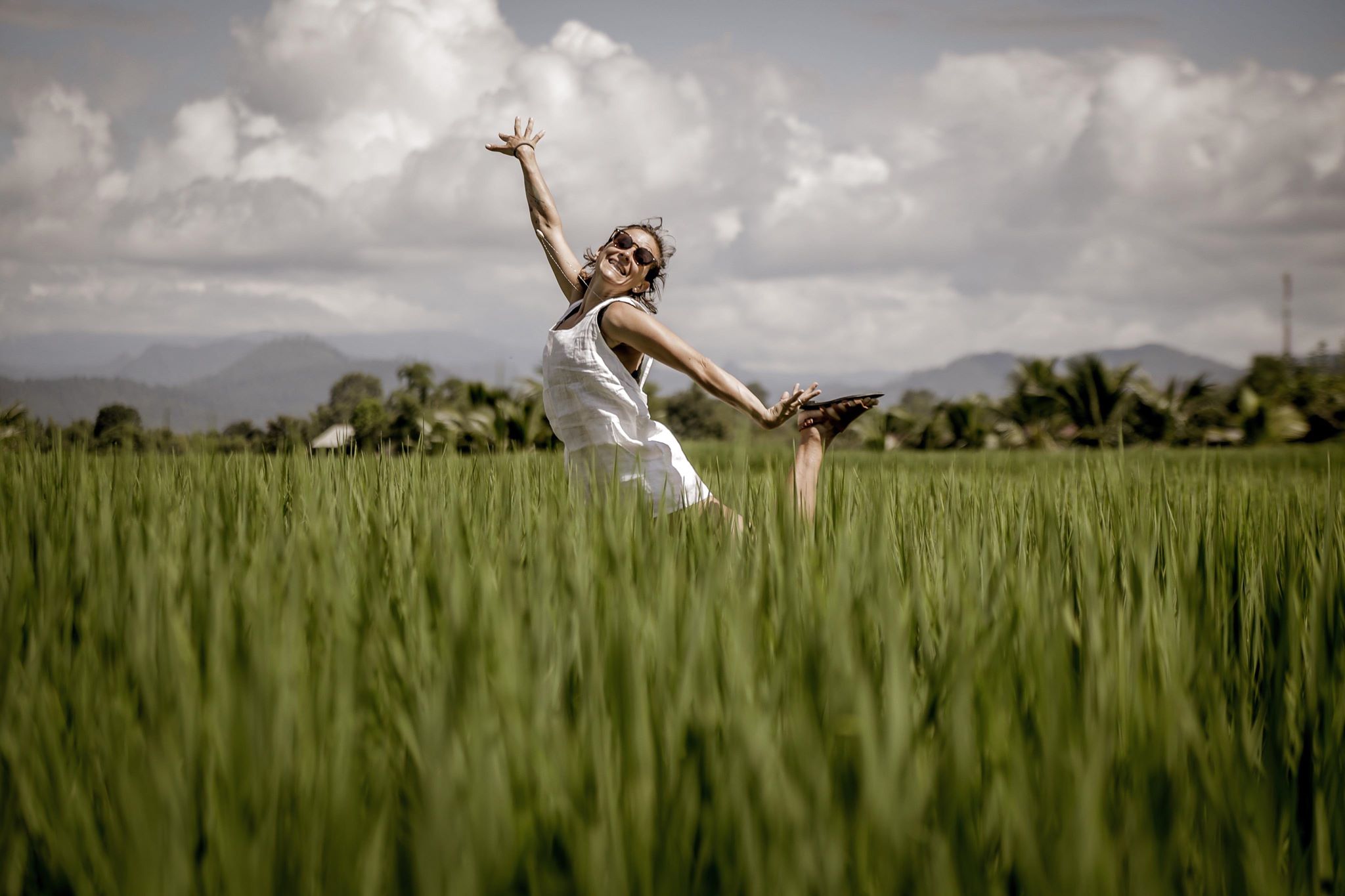 mulher pulando em campos de arroz