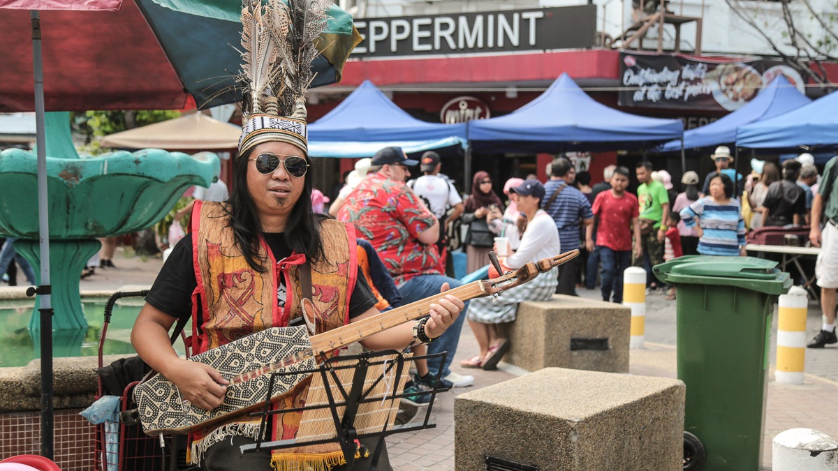 músico da malásia com roupas de sua tribo e um cocar