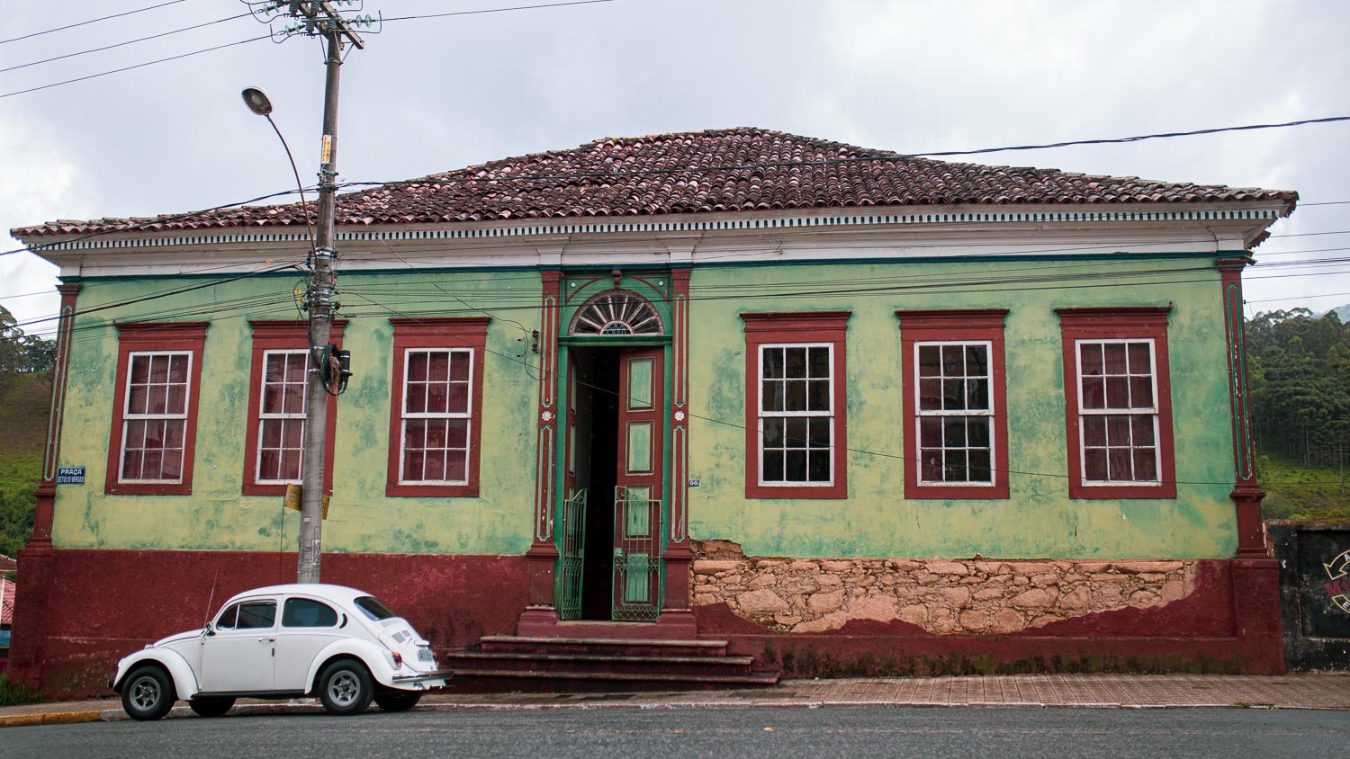 casarões de delfim moreira, com um fusca branco em frente a casa verde com janelas vermelhas