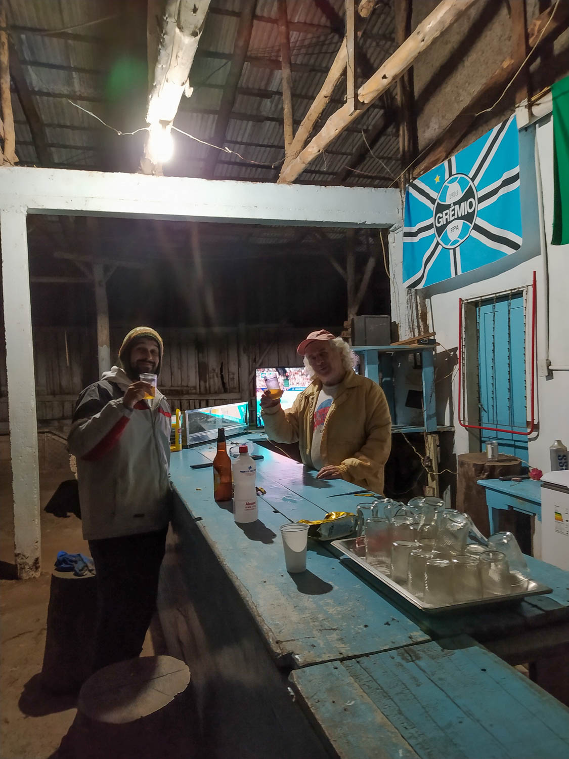 dois homens tomando cerveja no bolicho