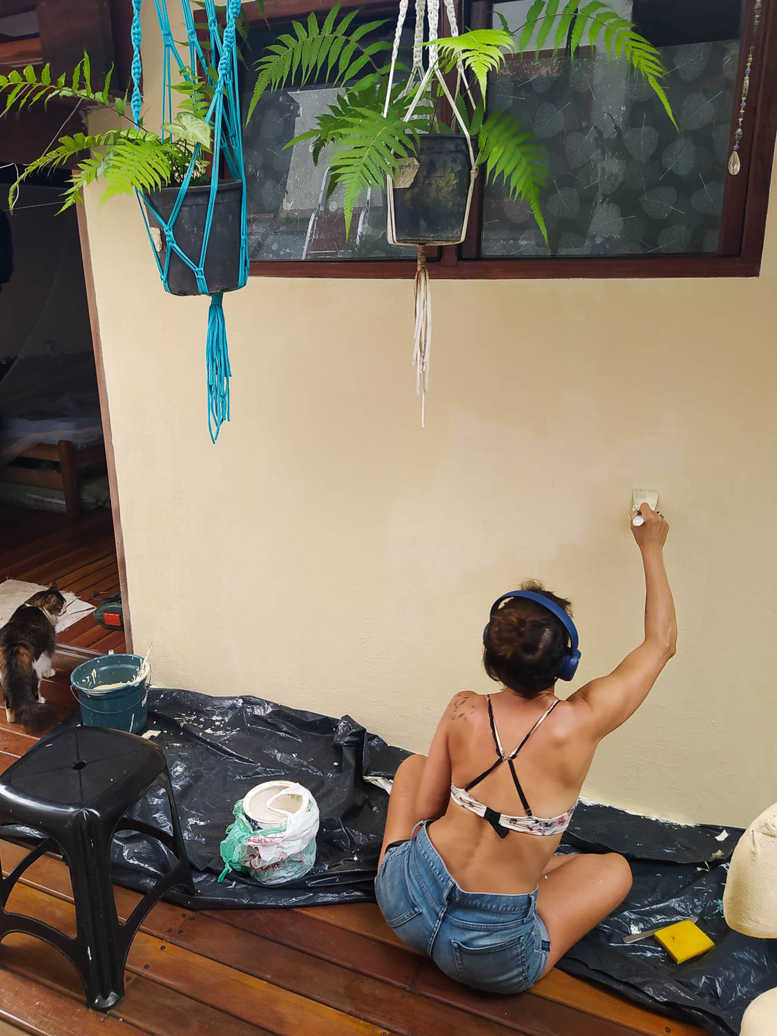 mulher pintando uma parede de costas