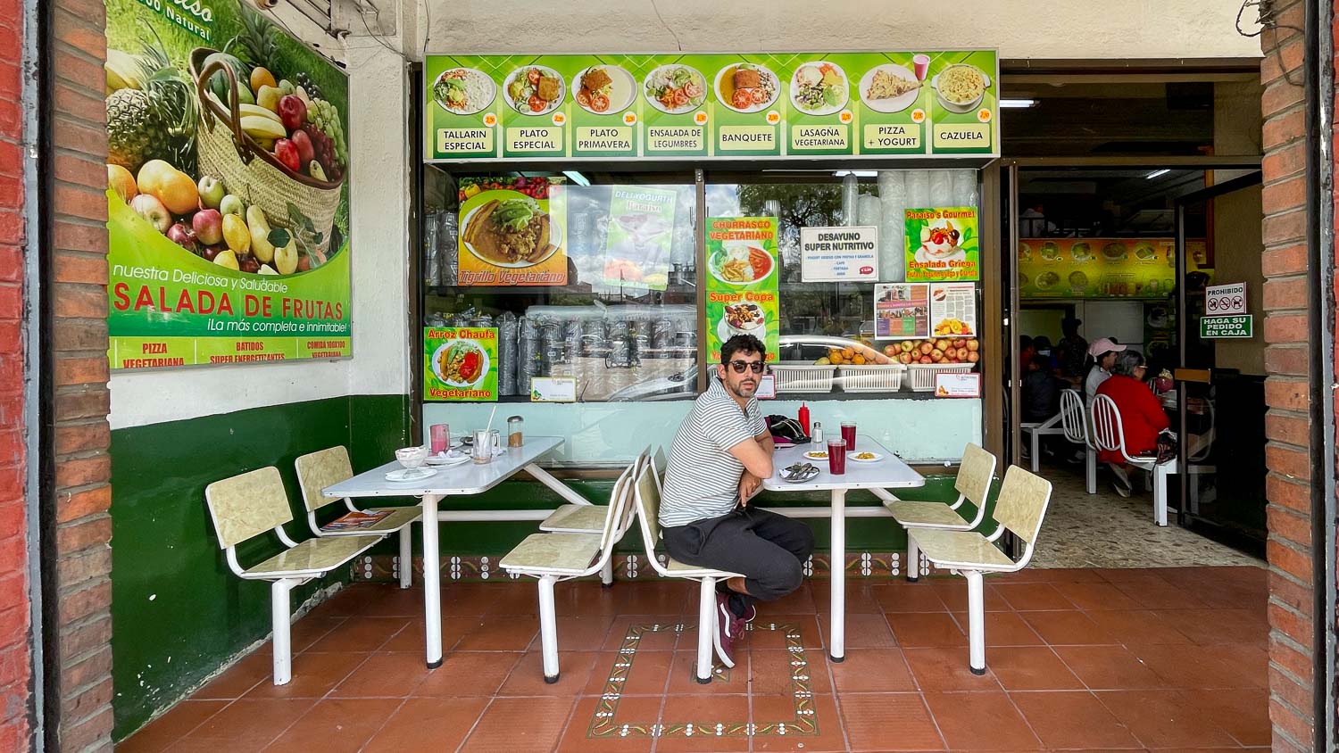 homem sentado em uma mesa de restaurante vegetariano