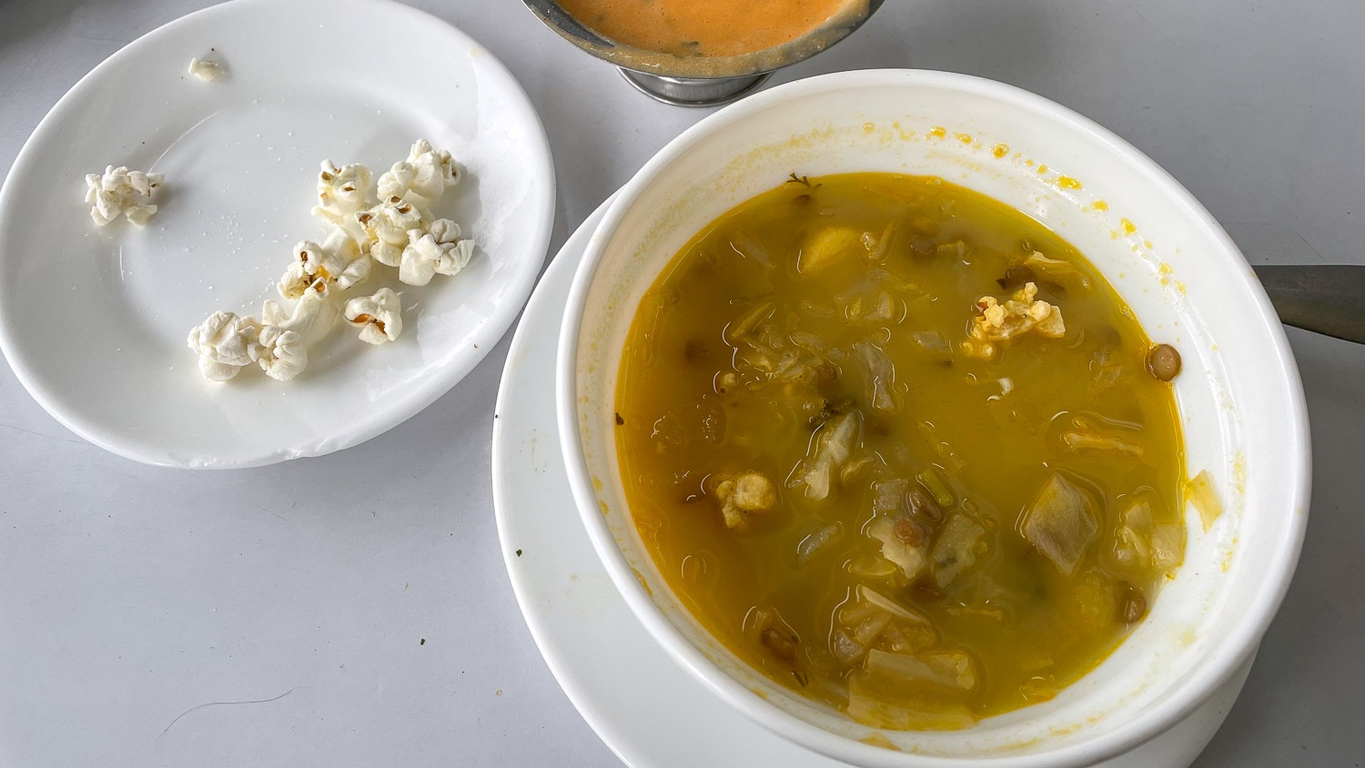 um prato de sopa servido com pipoca