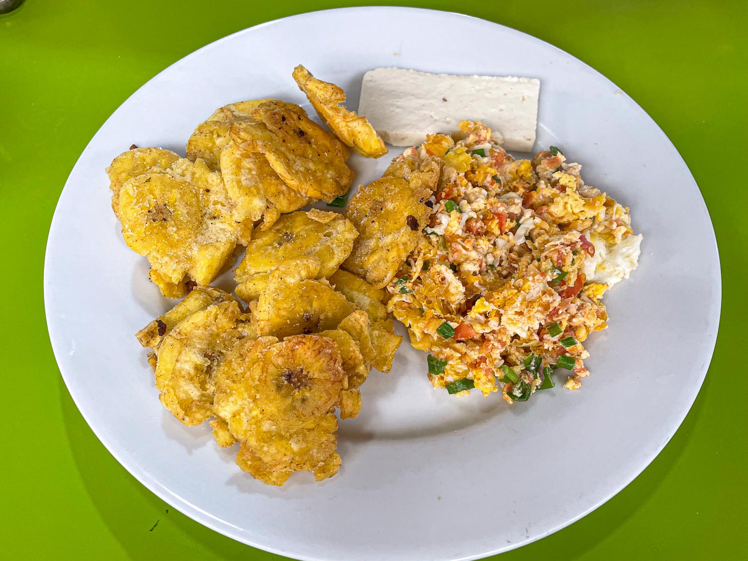 prato com patacones, omelete e uma fatia de queijo branco 