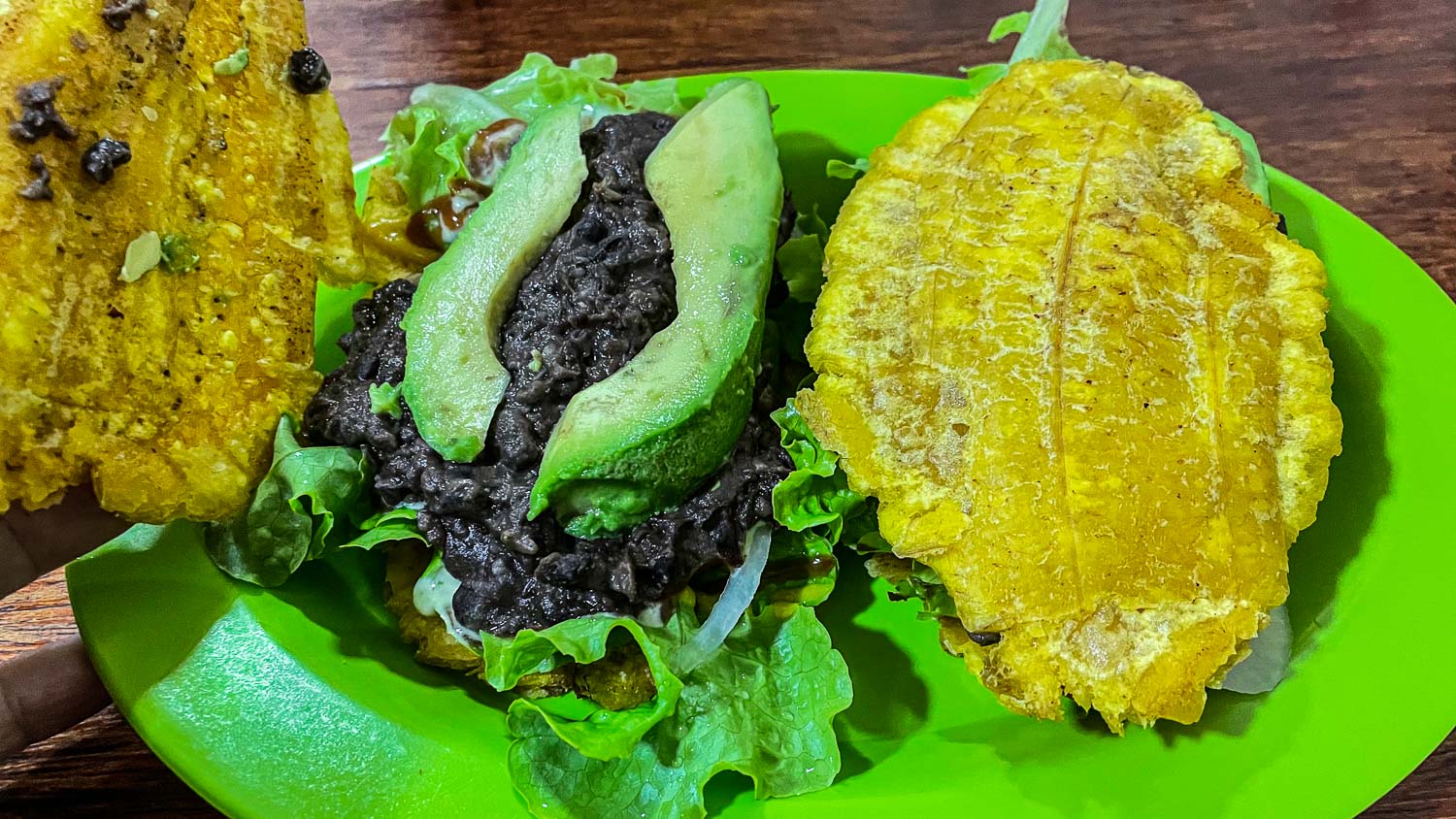 dois patacones: bananas fritas com recheio de feijão e abacate